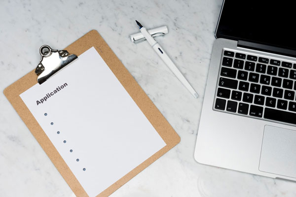 Photograph of a laptop and a clipboard